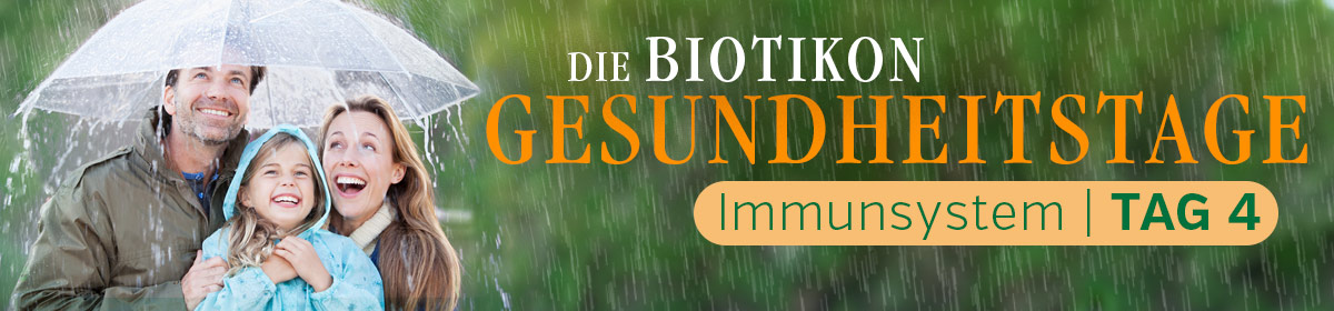 Immune System – Biotikon Health Days Family under an umbrella, smiling in the rain, green surroundings, experience of the Health Days.
