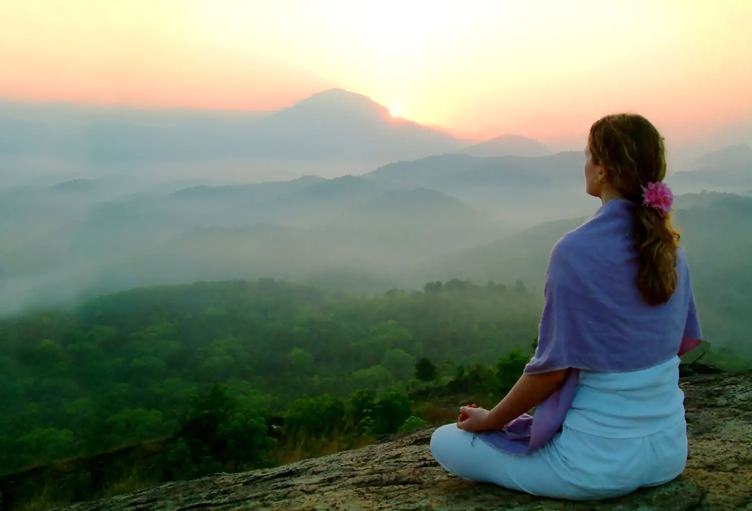 Woman meditating in nature with the rising sun Woman meditating in nature with the rising sun