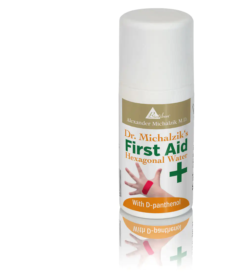Hexagonal Water - First Aid Spray First aid spray with hexagonal water, 100 ml, containing D-Panthenol, white bottle, hand with bandage in the background.